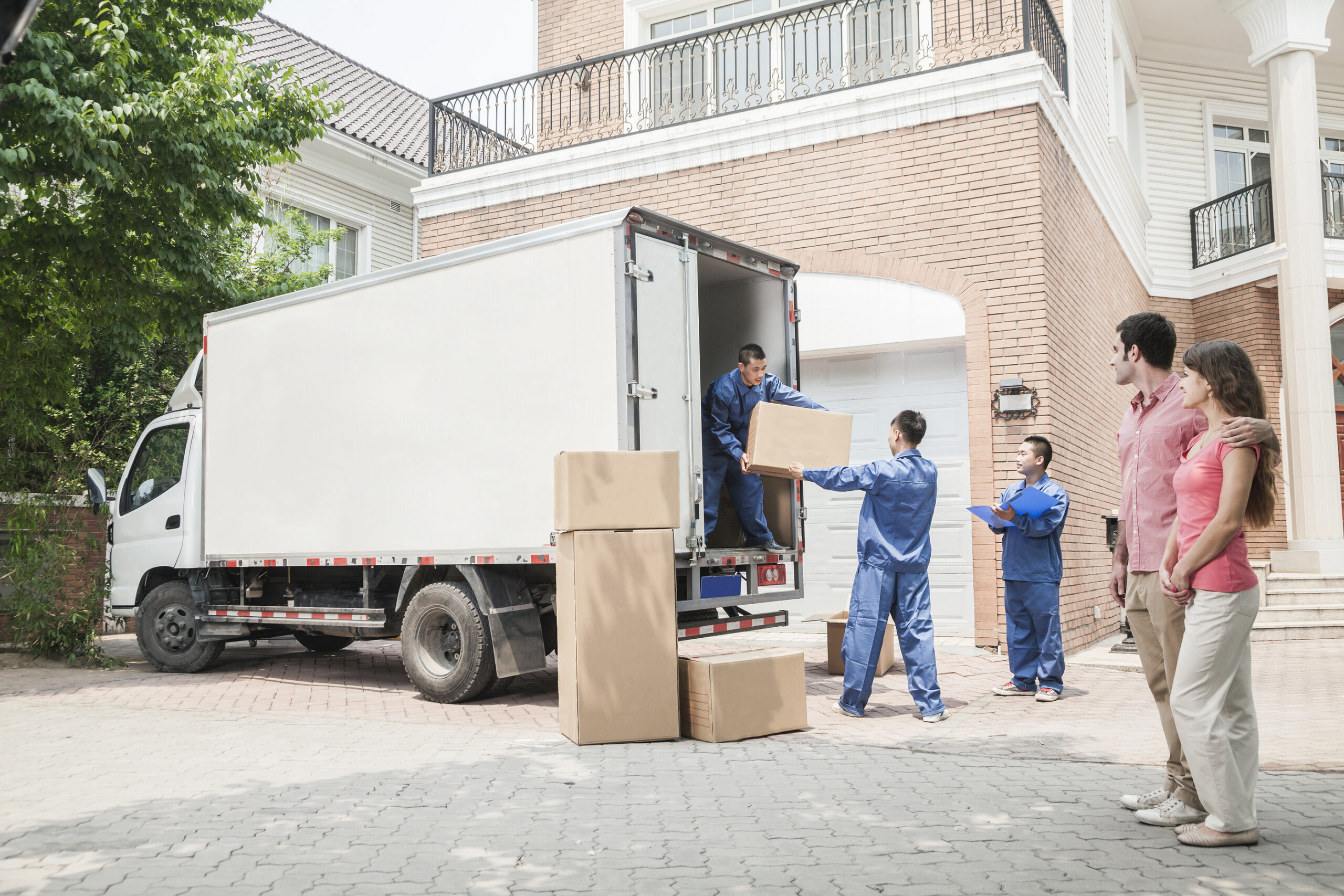 Wheat Ridge Movers professional packers wrapping and boxing belongings while a young couple looks on